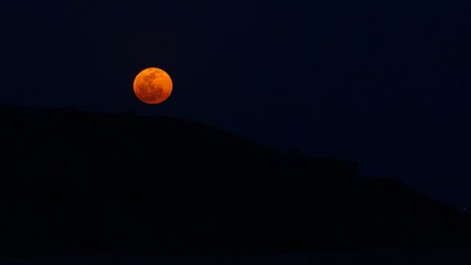 Majestic blood moon over silhouetted mountains, Ranikot, Sindh, Pakistan