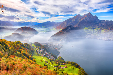Fabulous autumn view of Stansstad city and Lucerne lake with mountaines and fog.