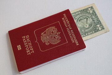 1 one dollar bill lie in red passport of Russian Federation. US dollar banknote inserted in Russian passport isolated on white background. Concept travel on with cash due to international sanction