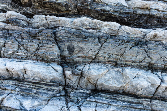 Nature force compressed cracked rock layers structure formation close-up details, in various shapes, colors, thicknesses, at south central coast of Crete, Greece. Nature and Geological science concept