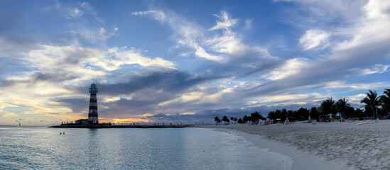 Fototapeta premium Panoramic shot of a summer cloudy afternoon with a lighthouse in the background.Copy space. Banner for travel promotion