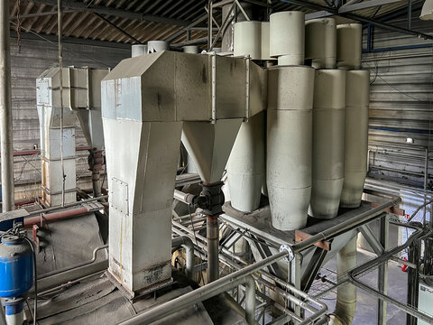 Exhaust gas ducts with a through dust collector and a cyclone battery and an industrial chimney, part inside the building