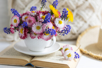 Flower arrangement with daisy and other summer flowers in a white cup. Spring floral composition. Greeting postcard for Mother's or Women's day, birthday, anniversary. Cozy atmosphere