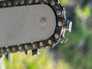 Close-up of a chain on the guide bar of a small wood chainsaw