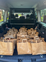 Packages with charity gifts for the elderly and those in need packed into the trunk of a car