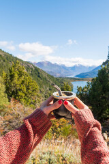 Woman holding and drinking a delicious Argentine mate in gaucho style while enjoying the beautiful landscapes of southern Argentina.