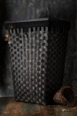 Large wicker basket near a gray plastered wall