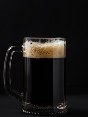 Draught dark beer mug on a black background