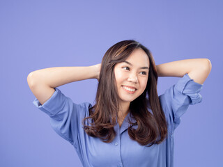 Portrait of an Indonesian Asian woman, wearing a blue shirt, smiling with her hands behind her...