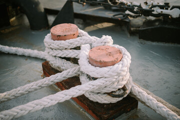 A ship's mooring rope tied to a dock, securing the vessel in place, ensuring stability and...
