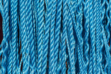 background close up of industrial blue ropes hanging vertically	