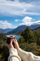 Woman's hands holding a delicious Argentine Mate during her summer vacation in Bariloche, Argentina.