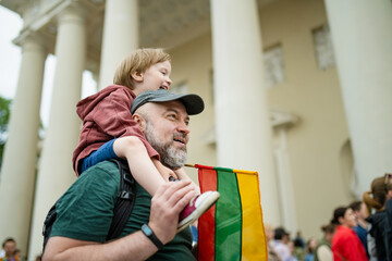 Cute little boy and his father holding tricolor Lithuanian flag celebrating Lithuanian Statehood...