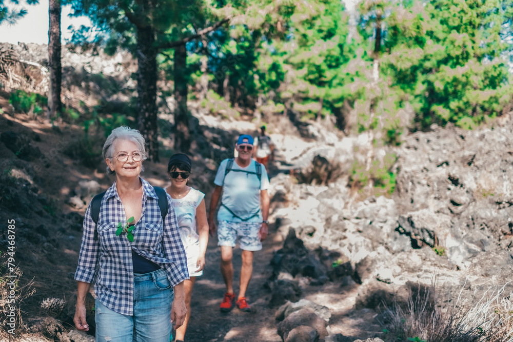 Sticker carefree group of senior people walking in mountain footpath enjoying healthy lifestyle and freedom 