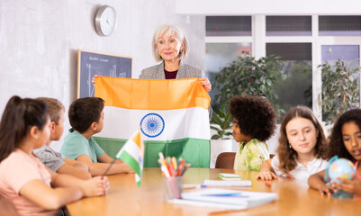 in entertaining geography lesson, children look at flag of India with interest