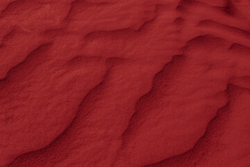 red desert sand shaped into waves by the wind