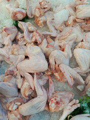 Chicken meat, liver, and feet arranged in a shop display for sale, showcasing a variety of poultry cuts and products available for purchase