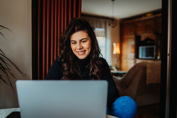 One young caucasian woman working on laptop from home