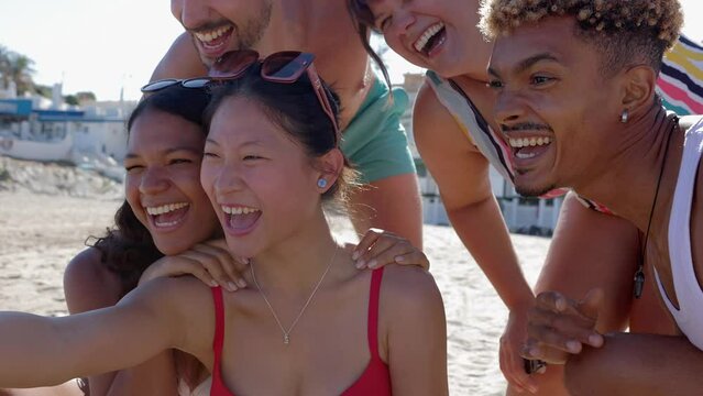 Diverse group of people having fun taking selfie portrait together enjoying summer vacation in the beach. Friendship and holidays concept.