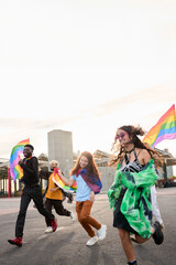 Vertical photo of a happy group of people are dancing down the street holding rainbow flags under the colorful sky, enjoying a lively event filled with fun and entertainment