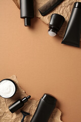 Flat lay composition with black cosmetic bottles on brown background. Men skin care concept.
