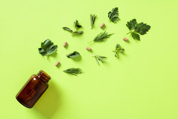 Natural nutritional supplements with leaves on green background. Flat lay. Top view