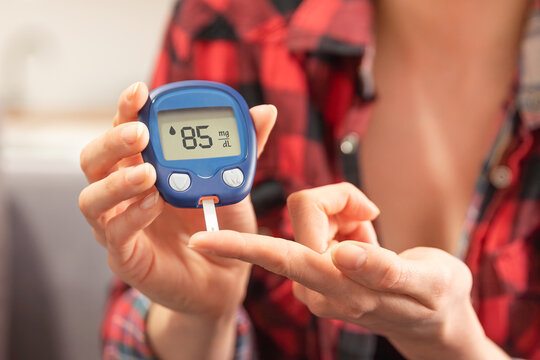 Woman using a glucose monitor. Diabetic disease