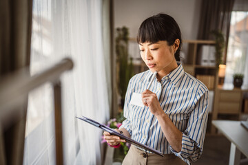 Portrait of japanese mature woman hold clipboard at office