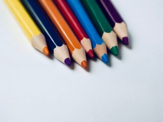 Obraz premium Colorful writing implements lined up on white surface