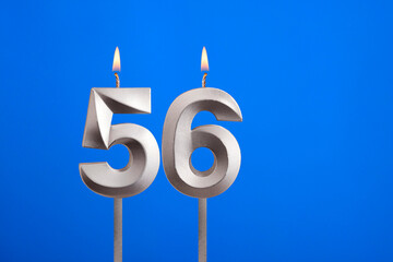 Birthday candle number 56 - Celebration card on blue background