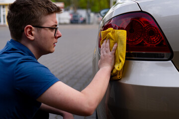Man cleaning a car with microfiber. Car Detailing. Car Cosmetics