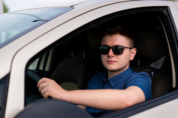 Driver wearing sunglasses, man driving a car, person in car, young driver
