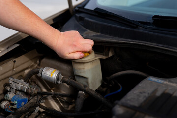 Checking the fluid level in the car's brake.