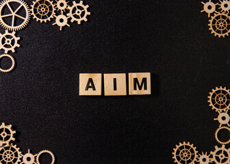 Wooden gears and AIM inscription on wooden cubes