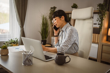 Mature japanese woman with eyeglasses talk on phone at the office