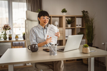 Mature japanese woman hold document and have consultation via video call
