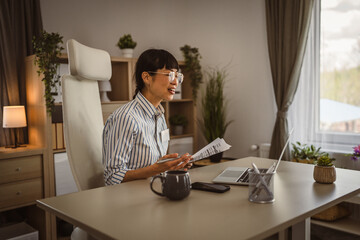 Mature japanese woman hold document and have consultation on video call