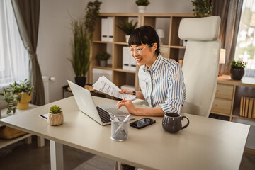 Mature japanese woman hold document and have consultation on video call
