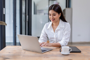 Asian Business woman using calculator and laptop for doing math finance on an office desk, tax, report, accounting, statistics, and analytical research concept
