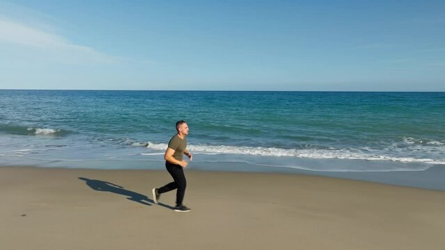 Pensive Man Running Sport On The Sandy Beach Near Ocean
