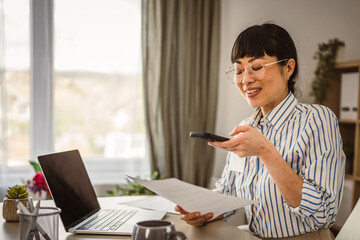 Mature japanese businesswoman with eyeglasses scan document at the office