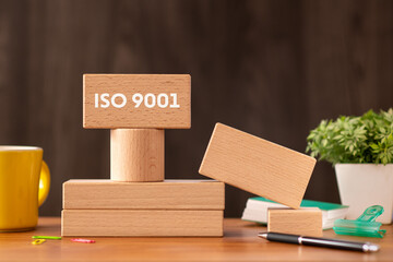 There is wood block with the word ISO 9001. It is as an eye-catching image.