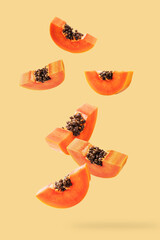 Falling papaya slice on light orange background. - 794545316