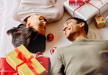 Gift, couple and happiness on floor for Christmas, smile and giving with love for holiday in...