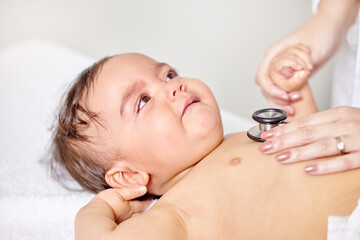 Sick baby, scared and doctor hands with stethoscope for check up, healthcare and illness in family...