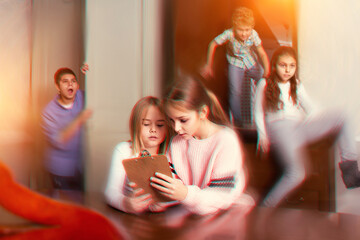 Two interested preteen girls trying to find solution of riddles in quest room, toned image