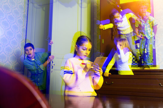 Focused tween children trying to solve riddles in quest room. Toned image with visual effect