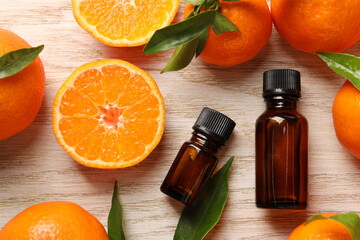 Flat lay composition with tangerine essential oil on wooden table
