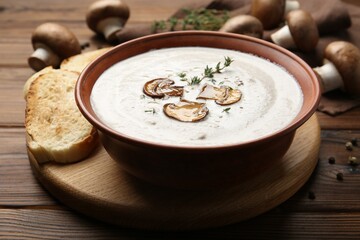 Fresh homemade mushroom soup in ceramic bowl on wooden table