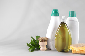 Bottles of cleaning product, brush and sponges on white background. Space for text - obrazy, fototapety, plakaty